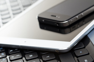 a phone and tablet stacked on top of a laptop